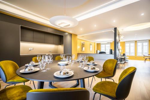 a dining room with a table and chairs at Les Suites 7 Anges - Parking, Vue Cathédrale & Centre Historique Reims in Reims