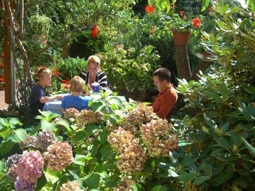 a group of people sitting around a table in a garden at Ferienwohnung Helbig in Tätzschwitz