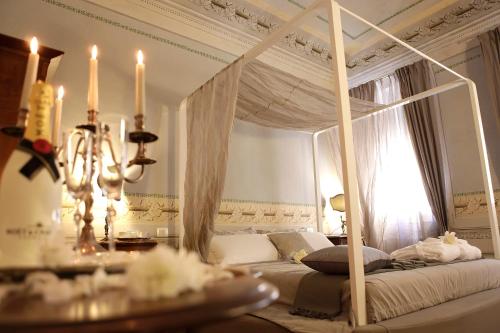 a bedroom with a canopy bed with a chandelier at Residenza D'Epoca -Santa Caterina in Pisa
