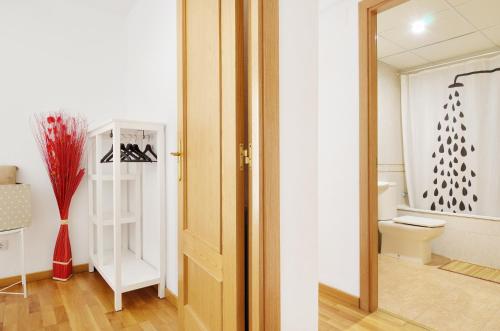 a bathroom with a toilet and a window and a door at Palacio de Los Luna in Zaragoza
