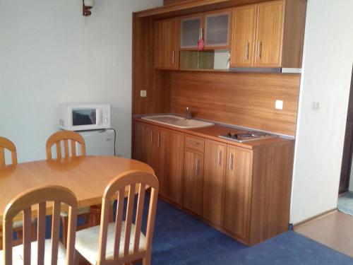 a kitchen with a table and a sink and a microwave at Byala Perla Family Hotel in Byala
