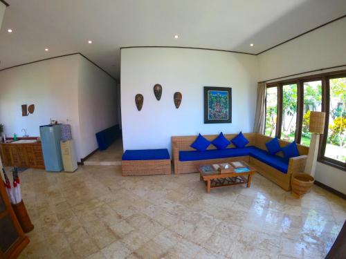 a living room with a blue couch and a table at Agung Bali Nirwana Villas and Spa in Tejakula