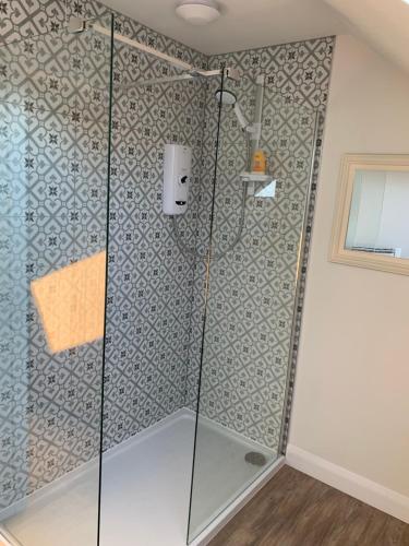 a shower with a glass door in a bathroom at The Piggery in Chichester