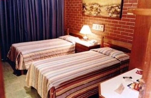 Habitación de hotel con 2 camas y mesa en Estancia Park Hotel, en Anápolis