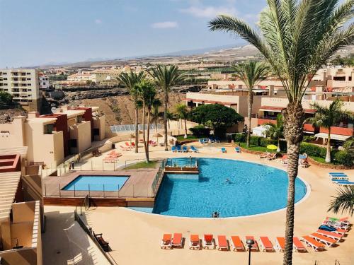 vistas a una piscina con palmeras y edificios en Casa Julia, en Playa Paraiso
