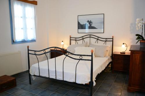een slaapkamer met een bed met een smeedijzeren frame bij Dolphin Studios in Astypalaia-stad (Chora)