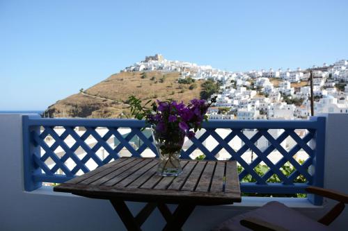 a vase of purple flowers sitting on a wooden table at Dolphin Studios in Astypalaia Town