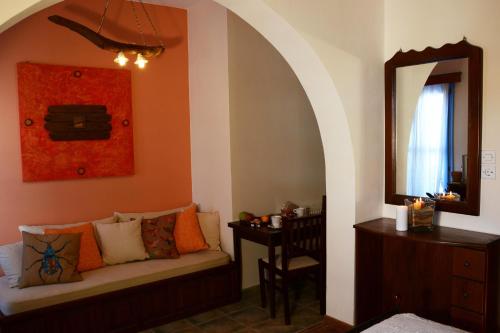 a living room with a couch and a mirror at Dolphin Studios in Astypalaia Town