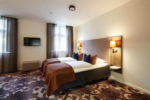En eller flere senge i et værelse på Hotel Vejlefjord