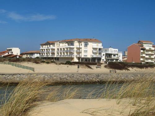 a building on the beach next to a beach at A Deux Pas du Courant in Mimizan-Plage