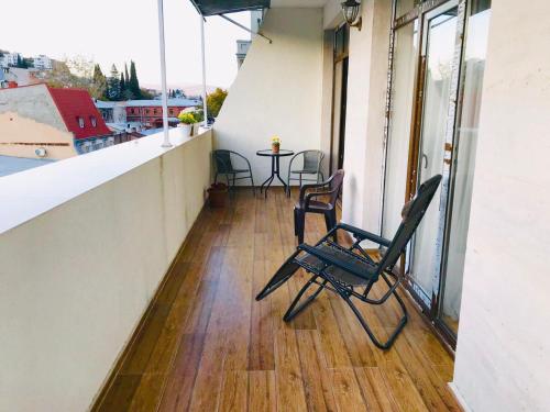 Un balcón con sillas y una mesa en un edificio. en Jasmine, en Tiflis