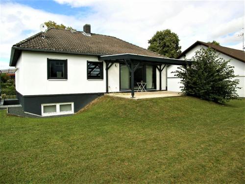 a white house with a grassy yard at Mergl's in Bad Schonborn