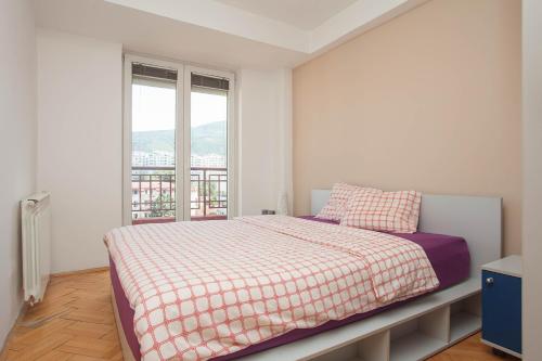 Un dormitorio blanco con una cama y una ventana. en RED APARTMENT, en Skopje