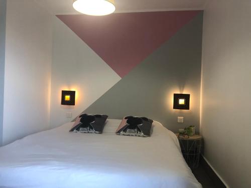 a bedroom with a bed with two pillows on it at Chambres d'Hôtes Poirier Bazin in Montry