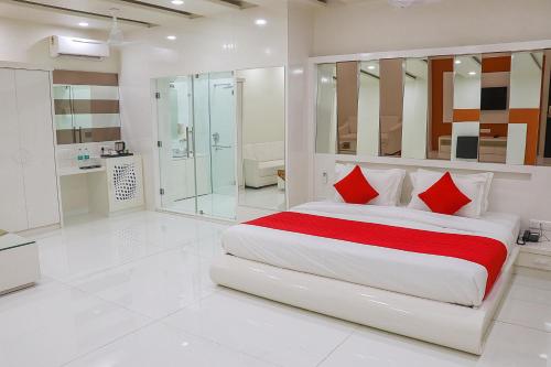 a white bedroom with a large bed with red pillows at Hotel Pushkar City Inn in Pushkar