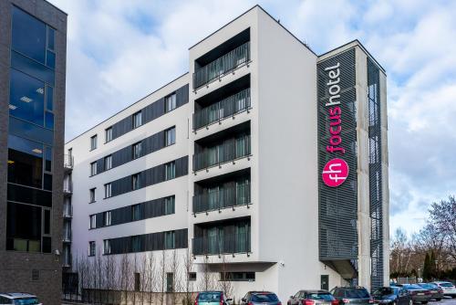 a large building with a sign on the side of it at Focus Hotel Poznań in Poznań