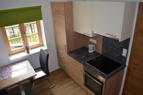 a kitchen with a counter and a table and a stove at Apart Garten Lutz in Prutz