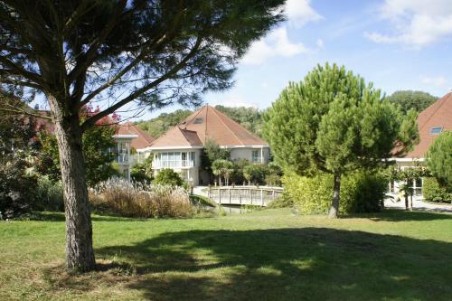 a group of houses in a yard with trees at Les Jardins de Beauval in Saint-Aignan
