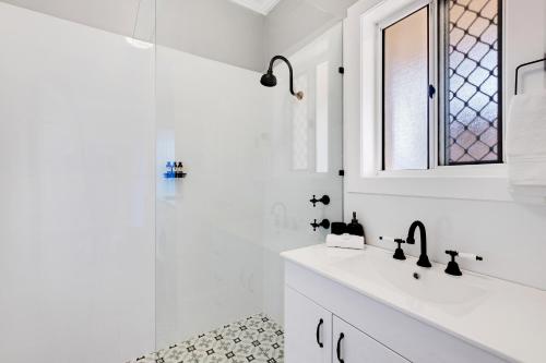 a white bathroom with a sink and a shower at Cute and Cosy - events, workers, getaways in Murray Bridge