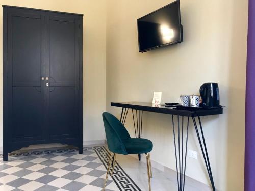 a room with a table and a chair and a television at Guest House La Grancontessa in Florence