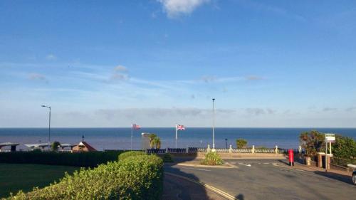 an empty road with two american flags and the ocean at The Golden Lion Hotel in Hunstanton
