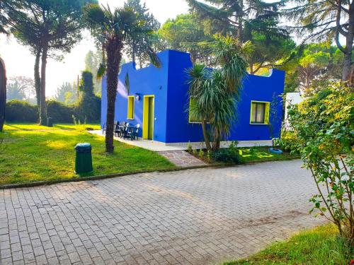 a blue house with palm trees in front of it at Villaggio Mithos in Misano Adriatico