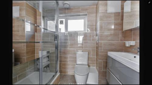 Lovely One Bedroom Apartment in Stratford في لندن: حمام مع مرحاض ومغسلة ودش