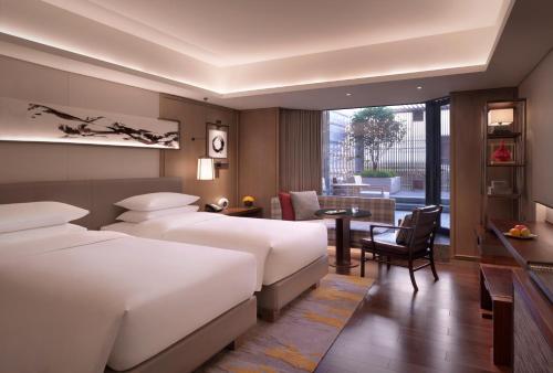 杭州市にあるGrand Hyatt Hangzhouのベッド2台とテーブルがあるホテルの部屋