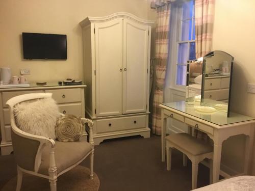 a room with a vanity and a dressing table and a mirror at Seaham in Weymouth