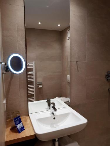 a bathroom with a white sink and a mirror at Apparthotel Garni Superior Simsseeblick in Bad Endorf