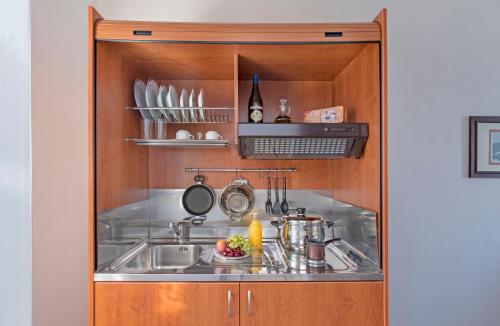 a kitchen with a sink in a wooden cabinet at Yalos rooms in Astypalaia Town