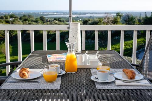 Una mesa con platos de croissants y vasos de zumo de naranja. en Casa Verdazul, en Tavira