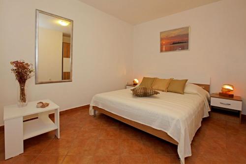 a bedroom with a white bed and a mirror at Villa Mariela in Korcula, heated pool in Vela Luka