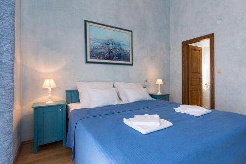 een slaapkamer met een blauw bed met 2 handdoeken erop bij Luxury Villa Maša in Dobrinj