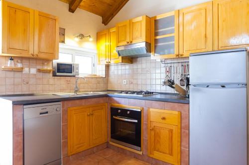 a kitchen with wooden cabinets and a white refrigerator at Villa Mariela in Korcula, heated pool in Vela Luka