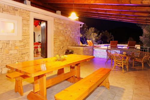 a wooden table and benches on a patio at Villa Mariela in Korcula, heated pool in Vela Luka