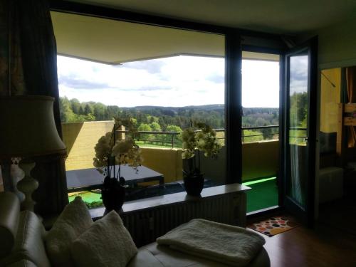 a living room with a large window with a view at Apartmenthotel Hohegeiß Kasing MIT FREIEM WLAN und Schwimmbad in Hohegeiß