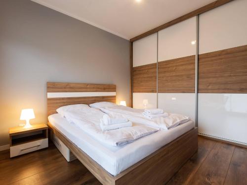 a bedroom with a large bed with white sheets at VacationClub – Bliżej Morza Apartament 98 in Kołobrzeg