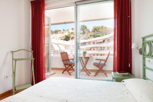 1 dormitorio con 1 cama y balcón con mesa y sillas en Lets Holidays Apartment Ancora 6, en Tossa de Mar