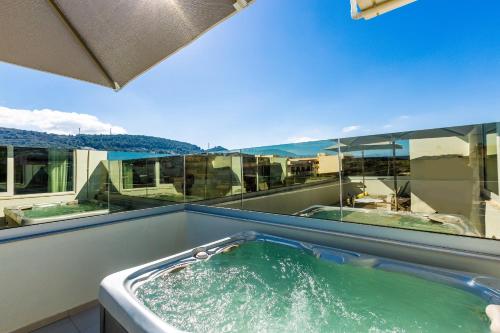 eine Whirlpool-Badewanne mit grünem Wasser auf dem Balkon in der Unterkunft Atrium Ambiance Hotel in Rethymno