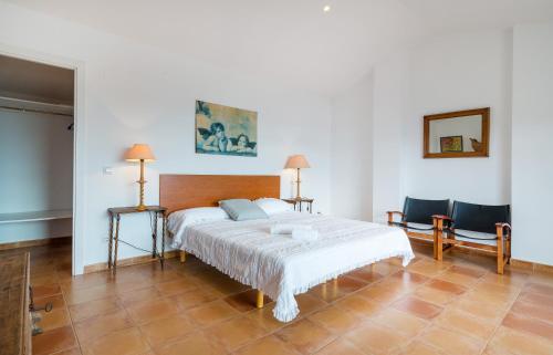 een slaapkamer met een groot bed en 2 stoelen bij CANADELL BLOC A, 2n 3a in Calella de Palafrugell