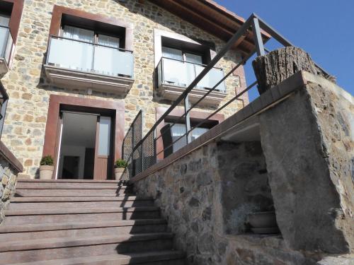 a brick house with stairs in front of it at Balcón de la Len in Quintana de Soba
