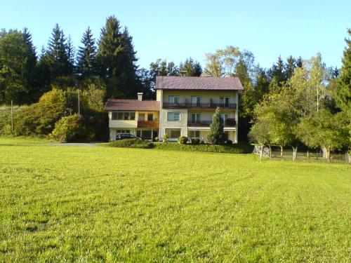 a large house with a large field in front of it at Sonnhügel Apartments - Ferienwohnungen in Faak am See