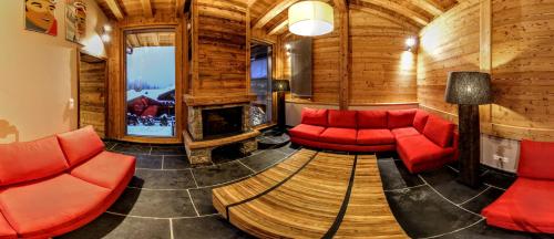 a living room with red chairs and a fireplace at Les Chalets d'Adelphine & SPA in Les Gets