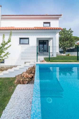 a house with a swimming pool in front of a house at Casa em Cascais in Cascais