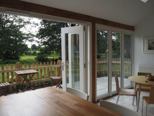 an open patio door with a table and chairs at Old Stables in Pulborough