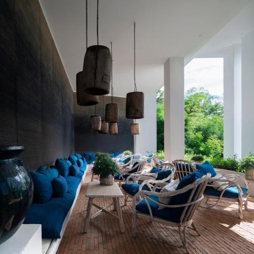 a living room with a blue couch and chairs at Raya Heritage - SHA Plus in Chiang Mai