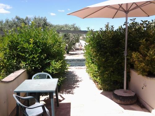 a patio with an umbrella and a table and chairs at B&B Terra Serena in Santa Cesarea Terme