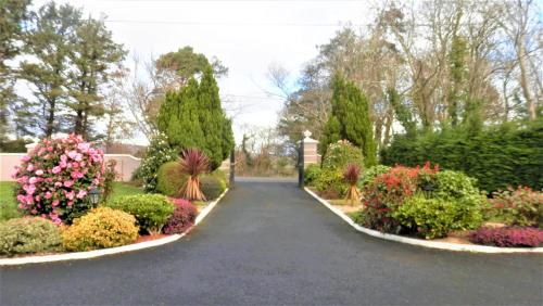 a walkway through a garden with flowers and trees at Leabrook House in Castlemaine