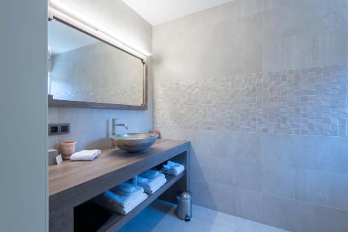 a bathroom with a sink and a mirror at Koru Hôtel & Private Wellness in Autre-Église